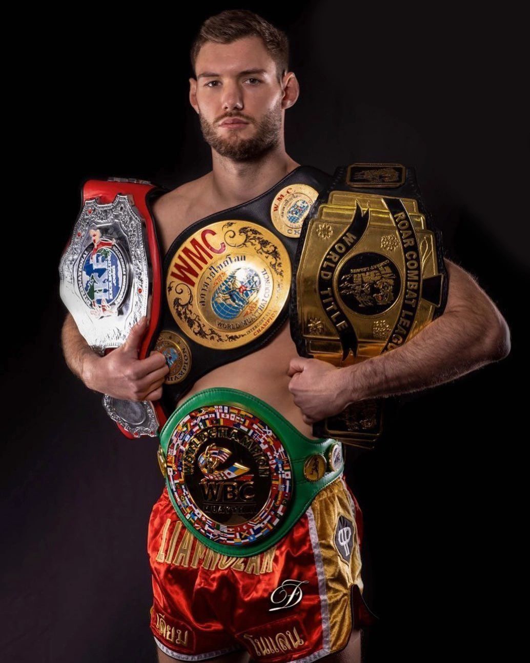 Nolan Muay Thai team group photo with championship belts