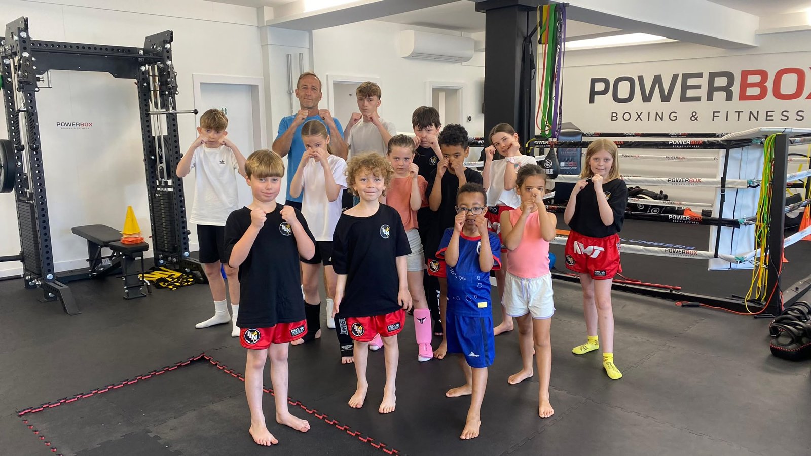 Kids Muay Thai class group photo with coach at PowerBox Boxing & Fitness